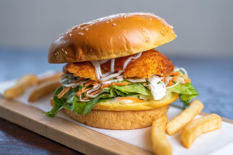 Burger z kurczakiem i frytki na talerzu
